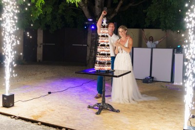 Un couple danse sur une piste extérieure éclairée, entouré de bulles, avec un DJ en arrière-plan.