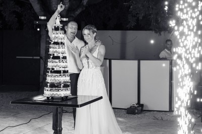 Un couple danse sur une piste extérieure éclairée, entouré de bulles, avec un DJ en arrière-plan.