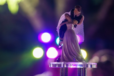 Un couple danse sur une piste extérieure éclairée, entouré de bulles, avec un DJ en arrière-plan.