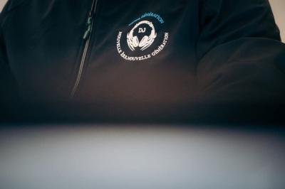 Veste noire avec un logo brodé représentant des mains entourant un disque, accompagné du texte ’Nouvelle Renouvelle…