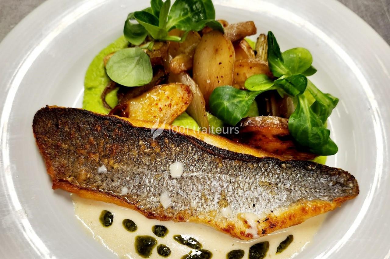Filet de poisson grillé servi avec purée verte, pommes de terre rôties, oignons caramélisés et feuilles de mâche.
