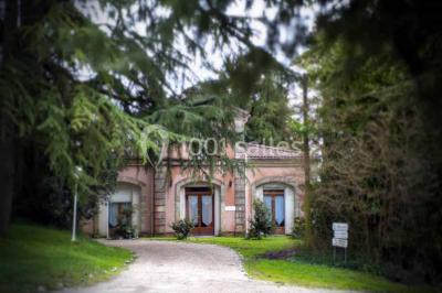 Disposition de bancs en bois face à une arche décorée pour une cérémonie en plein air, entourée de verdure.