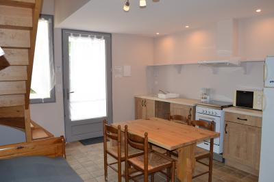 Disposition de bancs en bois face à une arche décorée pour une cérémonie en plein air, entourée de verdure.