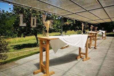 Disposition de bancs en bois face à une arche décorée pour une cérémonie en plein air, entourée de verdure.