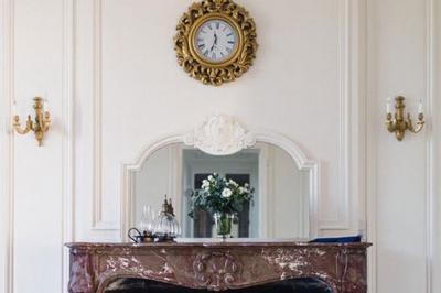 Disposition de bancs en bois face à une arche décorée pour une cérémonie en plein air, entourée de verdure.