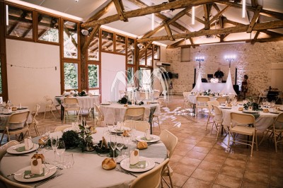 Disposition de bancs en bois face à une arche décorée pour une cérémonie en plein air, entourée de verdure.