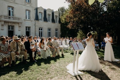 Groupe de personnes discutant sous des guirlandes lumineuses dans un jardin en soirée.