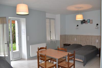 Groupe de personnes discutant sous des guirlandes lumineuses dans un jardin en soirée.