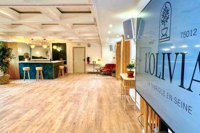 Entrée d'un restaurant aménagé sur un bateau, avec une passerelle en bois et des plantes en pot.