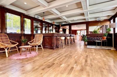 Entrée d'un restaurant aménagé sur un bateau, avec une passerelle en bois et des plantes en pot.