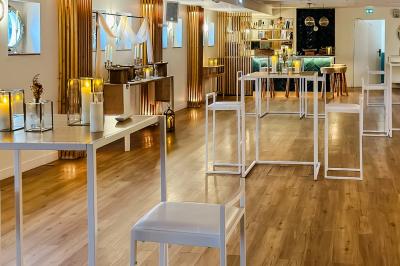 Entrée d'un restaurant aménagé sur un bateau, avec une passerelle en bois et des plantes en pot.
