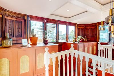 Entrée d'un restaurant aménagé sur un bateau, avec une passerelle en bois et des plantes en pot.