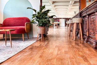 Entrée d'un restaurant aménagé sur un bateau, avec une passerelle en bois et des plantes en pot.