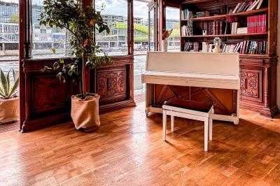 Entrée d'un restaurant aménagé sur un bateau, avec une passerelle en bois et des plantes en pot.