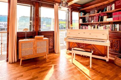 Entrée d'un restaurant aménagé sur un bateau, avec une passerelle en bois et des plantes en pot.