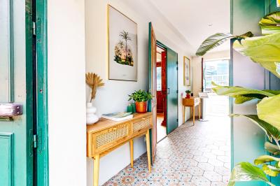 Entrée d'un restaurant aménagé sur un bateau, avec une passerelle en bois et des plantes en pot.