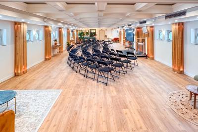 Entrée d'un restaurant aménagé sur un bateau, avec une passerelle en bois et des plantes en pot.