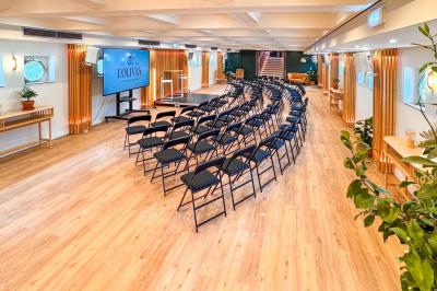 Entrée d'un restaurant aménagé sur un bateau, avec une passerelle en bois et des plantes en pot.