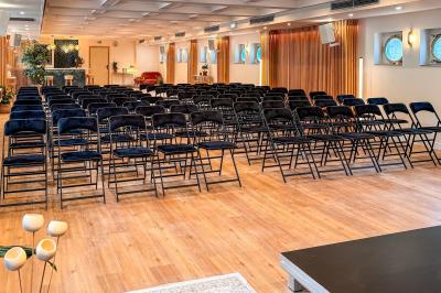 Entrée d'un restaurant aménagé sur un bateau, avec une passerelle en bois et des plantes en pot.