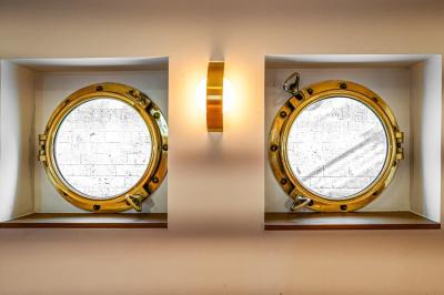 Entrée d'un restaurant aménagé sur un bateau, avec une passerelle en bois et des plantes en pot.