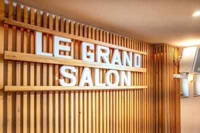 Entrée d'un restaurant aménagé sur un bateau, avec une passerelle en bois et des plantes en pot.