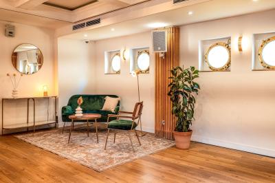 Entrée d'un restaurant aménagé sur un bateau, avec une passerelle en bois et des plantes en pot.