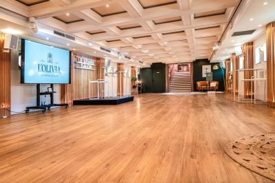 Entrée d'un restaurant aménagé sur un bateau, avec une passerelle en bois et des plantes en pot.
