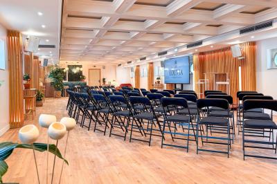 Entrée d'un restaurant aménagé sur un bateau, avec une passerelle en bois et des plantes en pot.