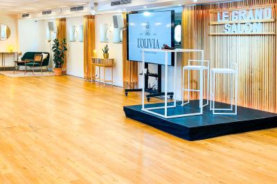 Entrée d'un restaurant aménagé sur un bateau, avec une passerelle en bois et des plantes en pot.