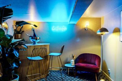 Entrée d'un restaurant aménagé sur un bateau, avec une passerelle en bois et des plantes en pot.