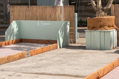 Entrée d'un restaurant aménagé sur un bateau, avec une passerelle en bois et des plantes en pot.