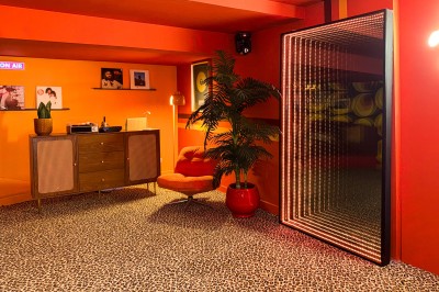 Miniature Location salle Paris 12 (Paris) - L'Olivia #121 Platine vinyle sur un meuble en bois, plante en pot et lampes dans une pièce aux tons rouges et orange.