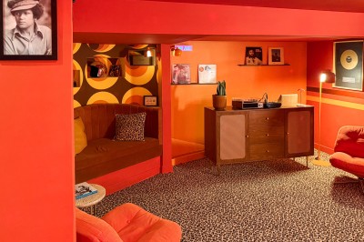 Miniature Location salle Paris 12 (Paris) - L'Olivia #126 Platine vinyle sur un meuble en bois, plante en pot et lampes dans une pièce aux tons rouges et orange.