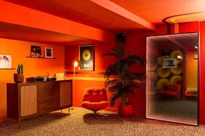 Miniature Location salle Paris 12 (Paris) - L'Olivia #130 Platine vinyle sur un meuble en bois, plante en pot et lampes dans une pièce aux tons rouges et orange.