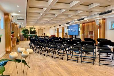 Panneau en bois indiquant les directions vers un jardin d'hiver et un boulodrome, entouré de verdure.