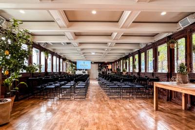 Panneau en bois indiquant les directions vers un jardin d'hiver et un boulodrome, entouré de verdure.