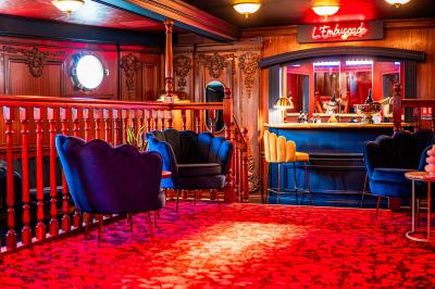 Panneau en bois indiquant les directions vers un jardin d'hiver et un boulodrome, entouré de verdure.