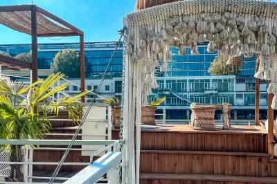 Panneau en bois indiquant les directions vers un jardin d'hiver et un boulodrome, entouré de verdure.