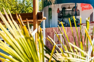 Panneau en bois indiquant les directions vers un jardin d'hiver et un boulodrome, entouré de verdure.