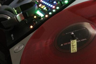 Équipement de DJ comprenant une table de mixage, des platines, un contrôleur et divers câbles sur une table.