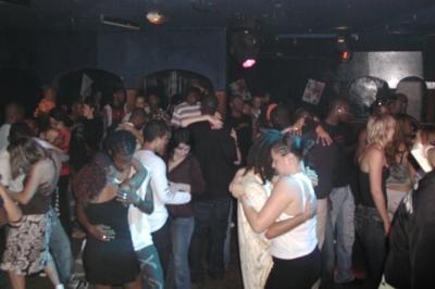 Platine vinyle avec disque rouge translucide en lecture, casque audio et table de mixage rétroéclairée en arrière-plan.