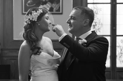 Un couple s'embrasse tendrement dans un cadre naturel entouré de branches d'olivier.