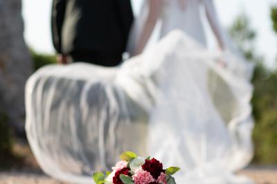 Un couple s'embrasse tendrement dans un cadre naturel entouré de branches d'olivier.