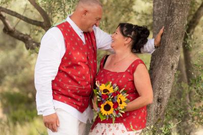 Un couple s'embrasse tendrement dans un cadre naturel entouré de branches d'olivier.