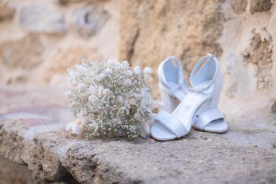 Un couple s'embrasse tendrement dans un cadre naturel entouré de branches d'olivier.