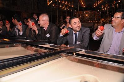 Femme portant des lunettes et un blazer à carreaux, posant devant un fond clair.