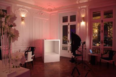 Femme souriante portant un blazer imprimé coloré, un t-shirt gris et un jean, posant devant un fond blanc.