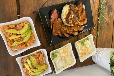 Pizza garnie de jambon cru, olives noires, artichauts, tomates séchées, fromage râpé et filet de pesto.