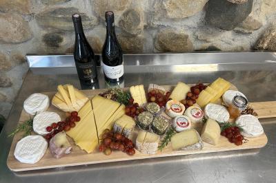 Pizza garnie de jambon cru, olives noires, artichauts, tomates séchées, fromage râpé et filet de pesto.