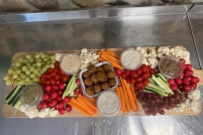 Pizza garnie de jambon cru, olives noires, artichauts, tomates séchées, fromage râpé et filet de pesto.